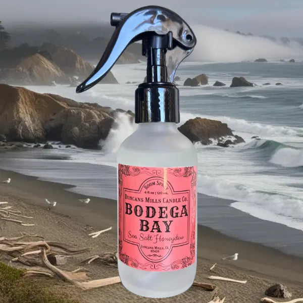 Bodega Bay spray bottle with pink label on a beach background