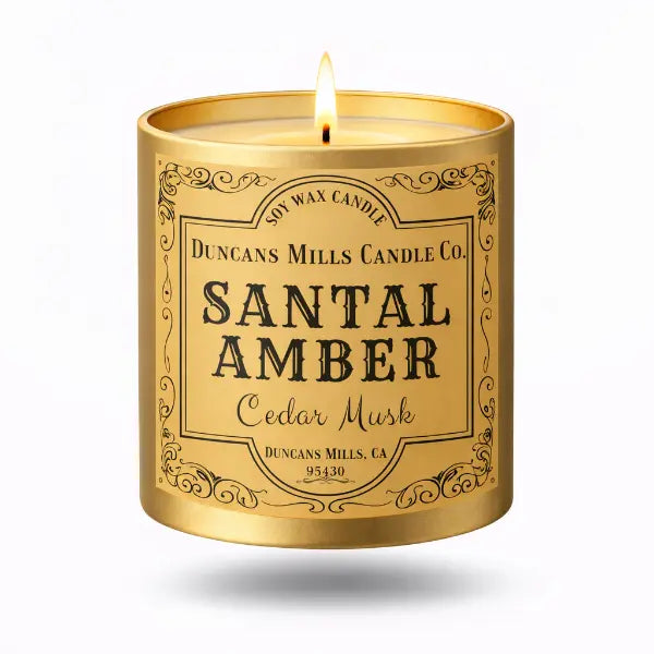 Gold candle tin labeled 'Santal Amber Cedar Musk' by Duncan's Mills Candle Co. on a white background.