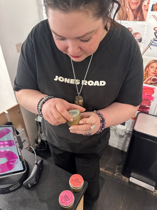 Jones Road Makeup Artist looking at Duncans Mills Candle Co. fragrant candles.