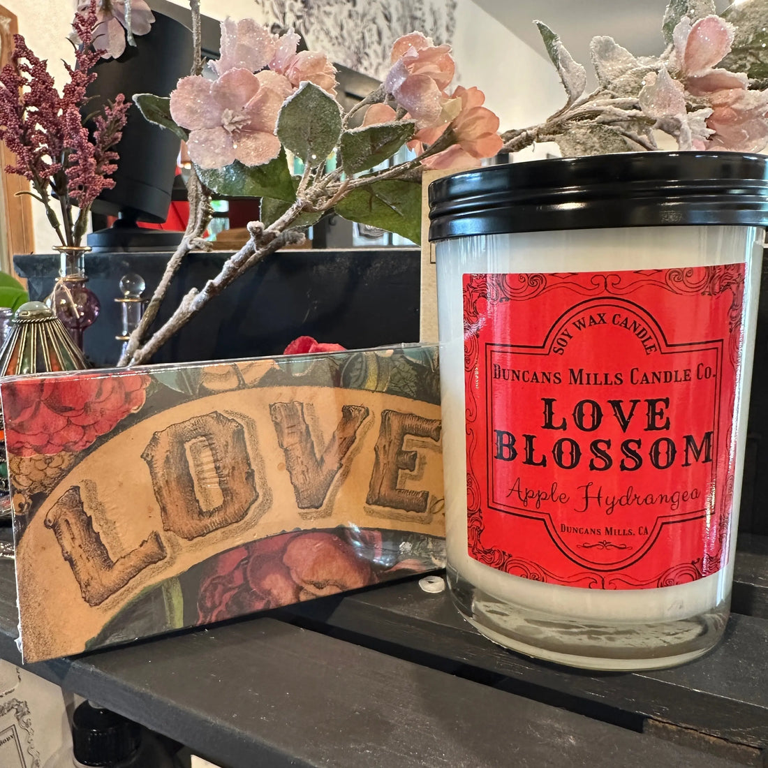 Pink Love Blossom cafe glass candle on a table with decorative love-themed matches by Duncans Mills Candle Co.