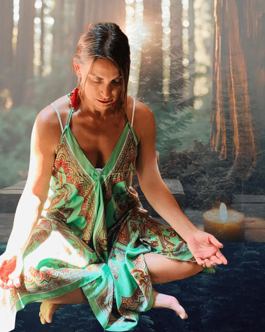 Lit candle in a tranquil redwood forest meditation setting evoking self-care and serenity at Duncans Mills