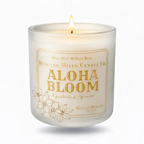 Candle with 'Aloha Bloom' label on a white background