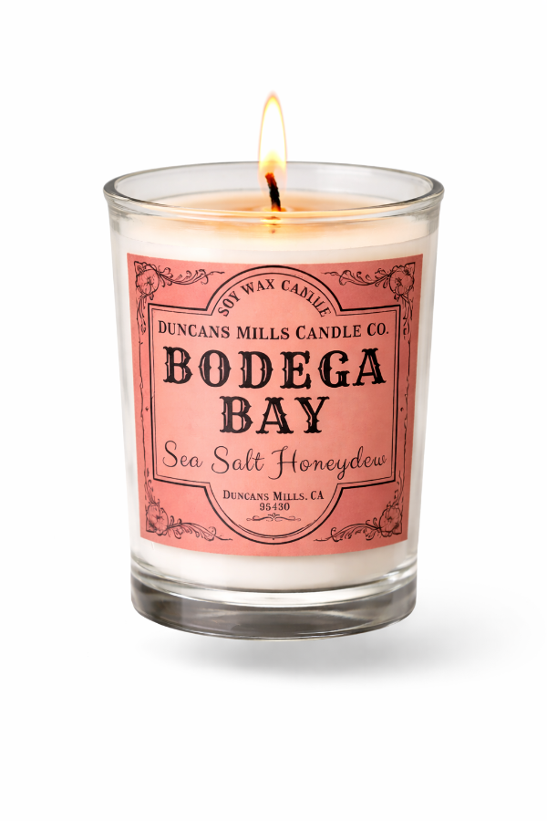 Candle in a glass jar with a Bodega Bay label on a white background