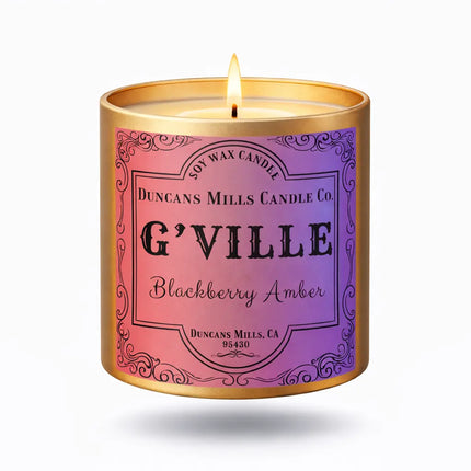 Candle in a decorative container labeled 'G'Ville Blackberry Amber' by Duncan Mills Candle Co.
