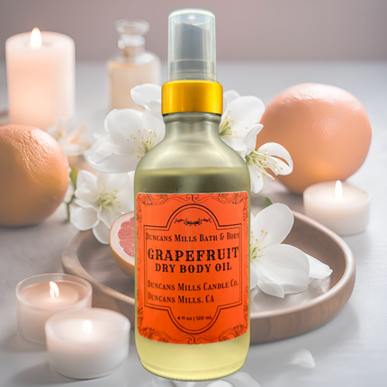 A sleek frosted glass bottle of Grapefruit Body Oil placed beside fresh grapefruit slices , candles and white flowers, radiating citrusy freshness and luxury self-care.
