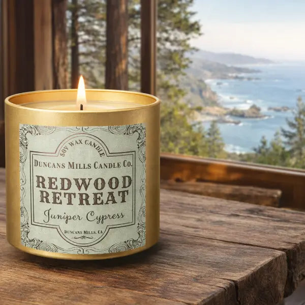 Redwood Retreat Infinity Tin Candle on Rustic Table with Window View of Sonoma   Coast
