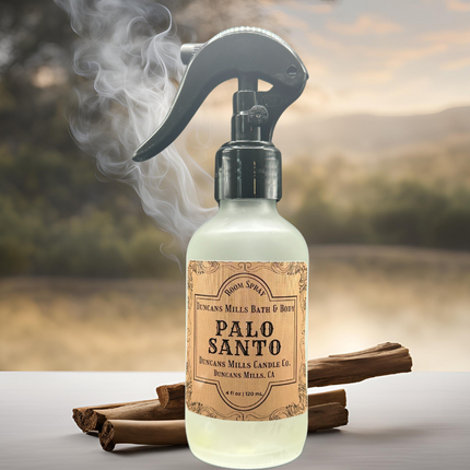 A close-up of Palo Santo Room & Linen Spray, highlighting its frosted glass bottle with black trigger sprayer. Crafted with phthalate-free fragrance oils and botanical-based humectants for a clean, nature-inspired scent experience.