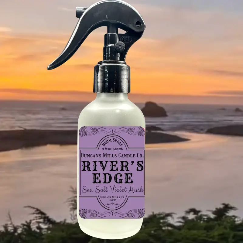 Spray bottle with 'River's Edge' label against a sunset beach backdrop