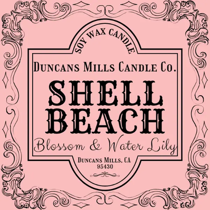 Label for Duncans Mills Candle Co. Shell Beach candle on a pink background with decorative border.
