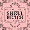 Label for Duncans Mills Candle Co. Shell Beach candle on a pink background with decorative border.