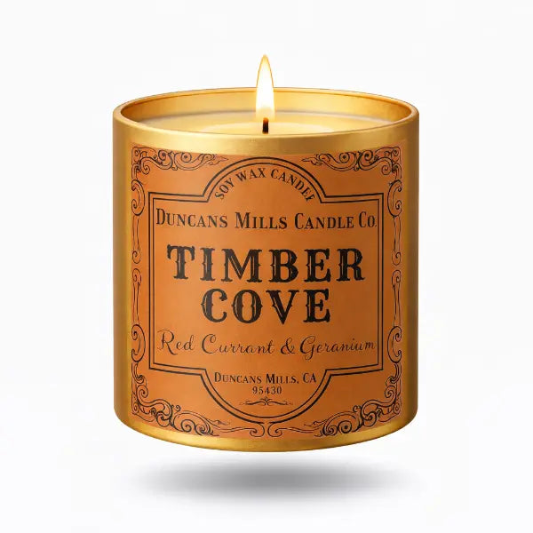 Candle in a decorative tin labeled 'Timber Cove' by Duncans Mills Candle Co.